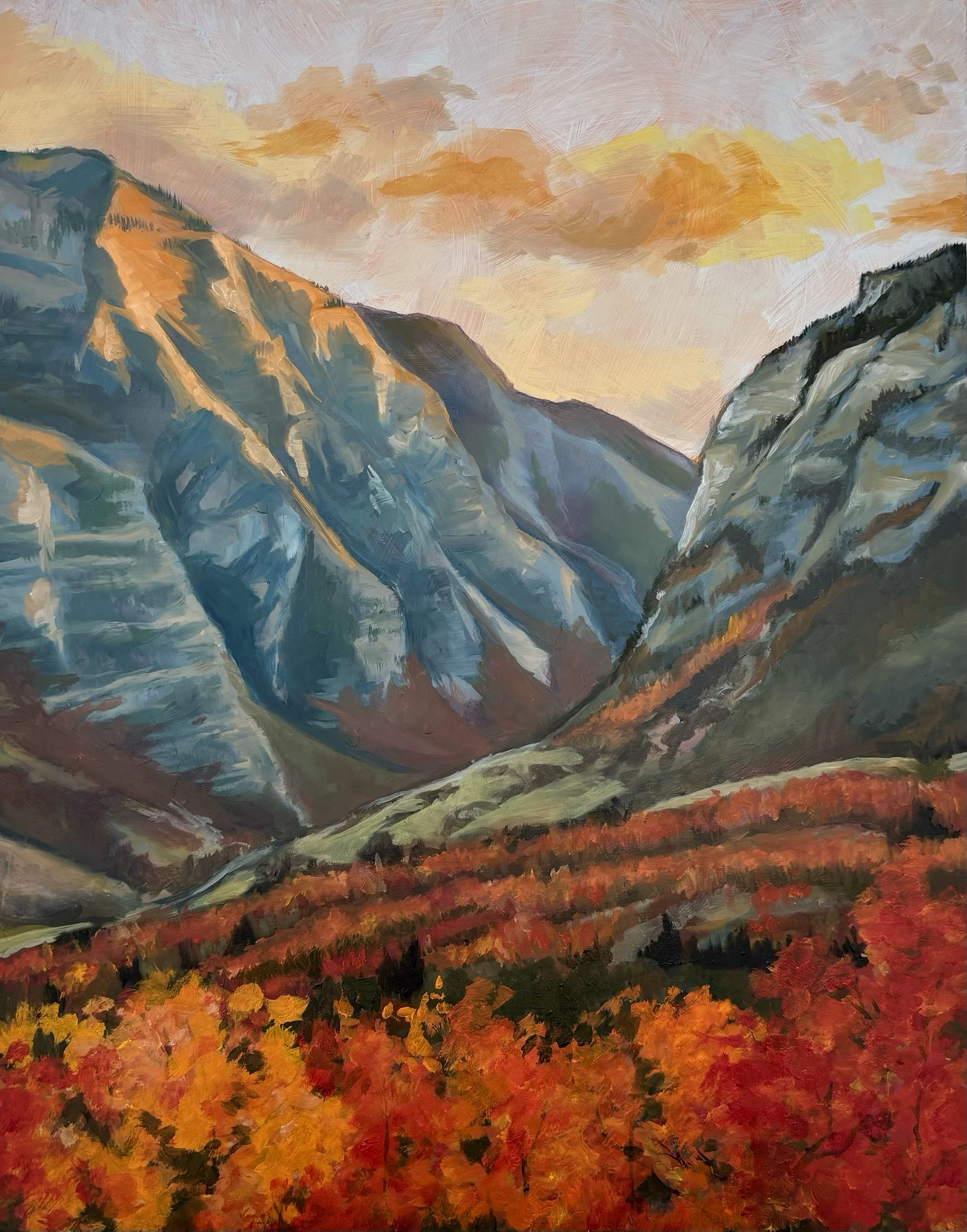 A painting of a sunlit view between two mountains with red and orange leaves at the base of them