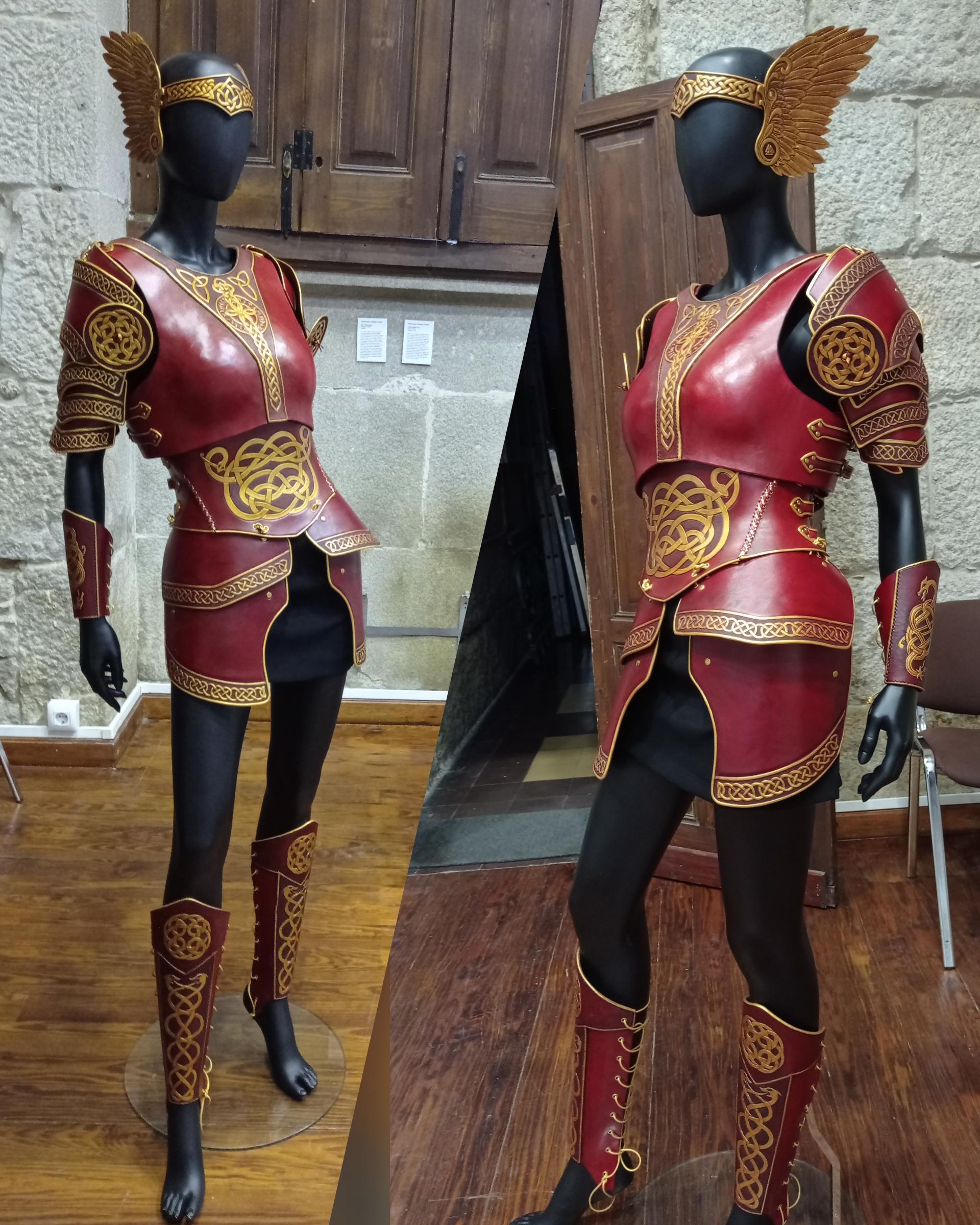 Two pics of the same armour on a black mannequin, in an old exposition room in wood and stone. The mannequin is visibly thinner than the woman before but the armour is aswell fit, making notable the fact that it is greatly adjustable. The different parts are now more appreciated, like the wings at the sides of the tiara, the decoration of the bracers and greaves and the straps of the cuirass and the corset