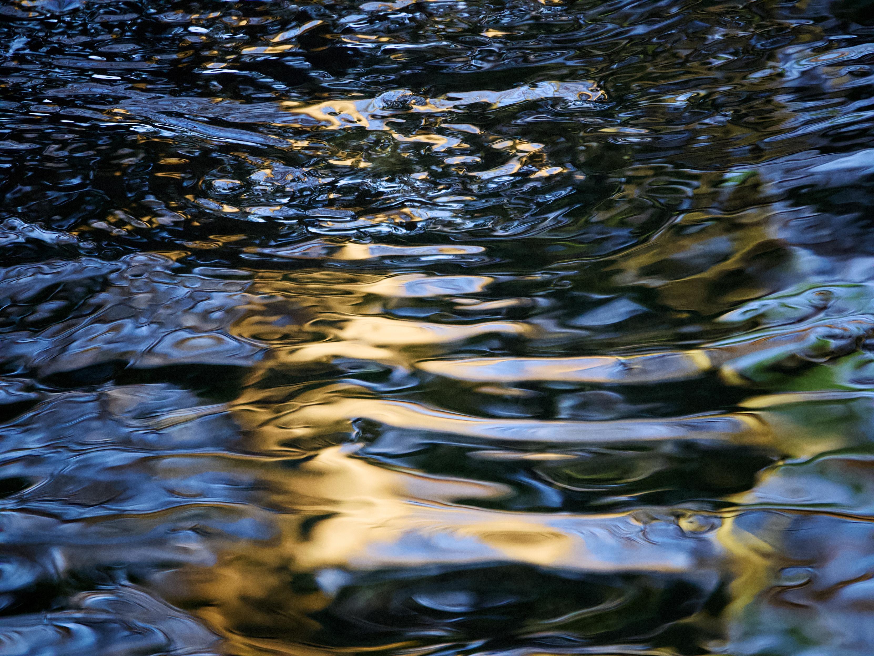 Sunlight glinting on the surface of a stream creates a dazzling, ever-changing pattern of reflections and shapes 