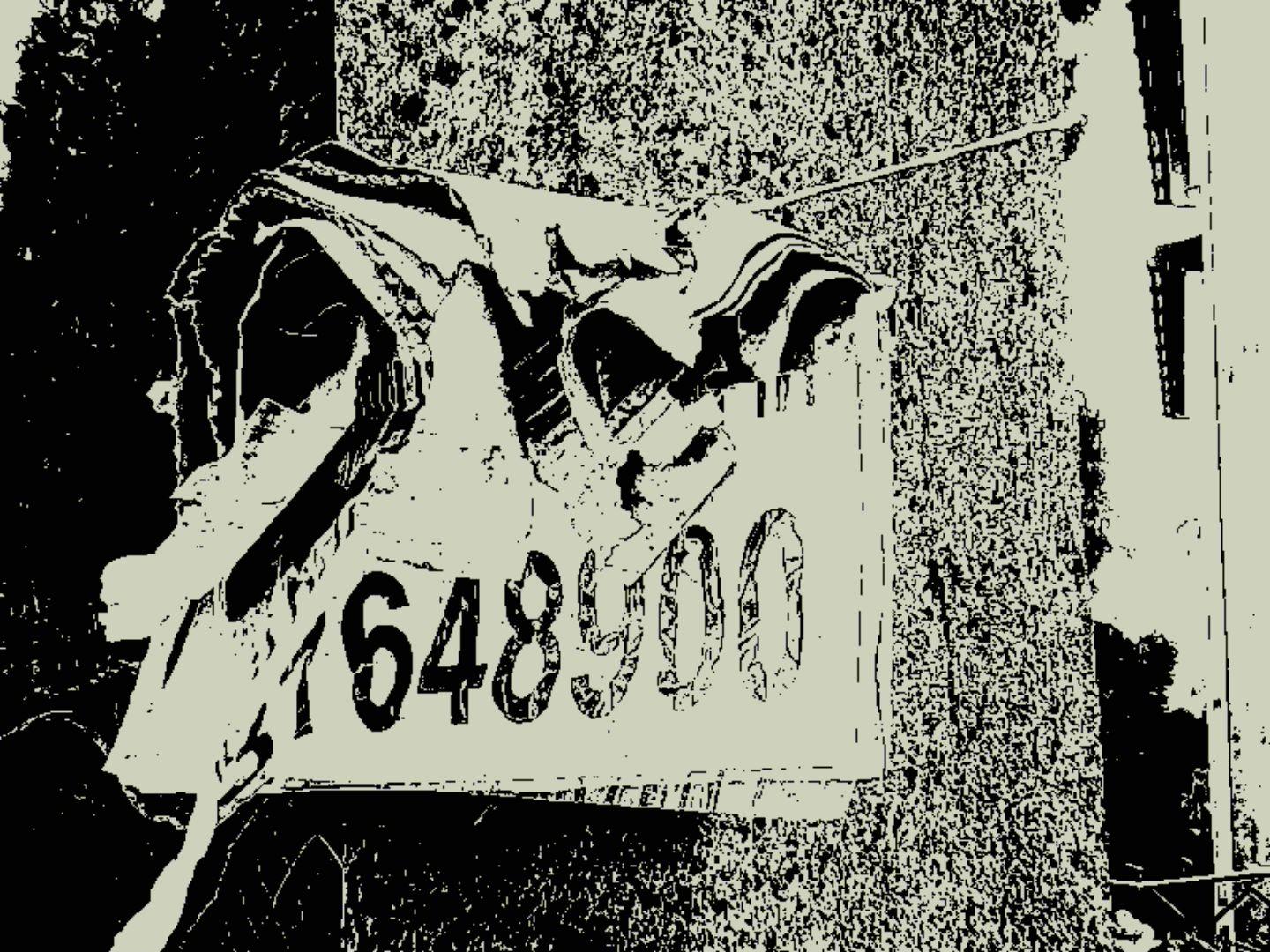 A layered cardboard notice with large numbers is attached to a concrete pole, its surface splitting and delaminating into rough fragments. The torn edges curl outward, emphasizing decay. The scene breaks into stark black and white patches with glitch-like artifacts and coarse texture.