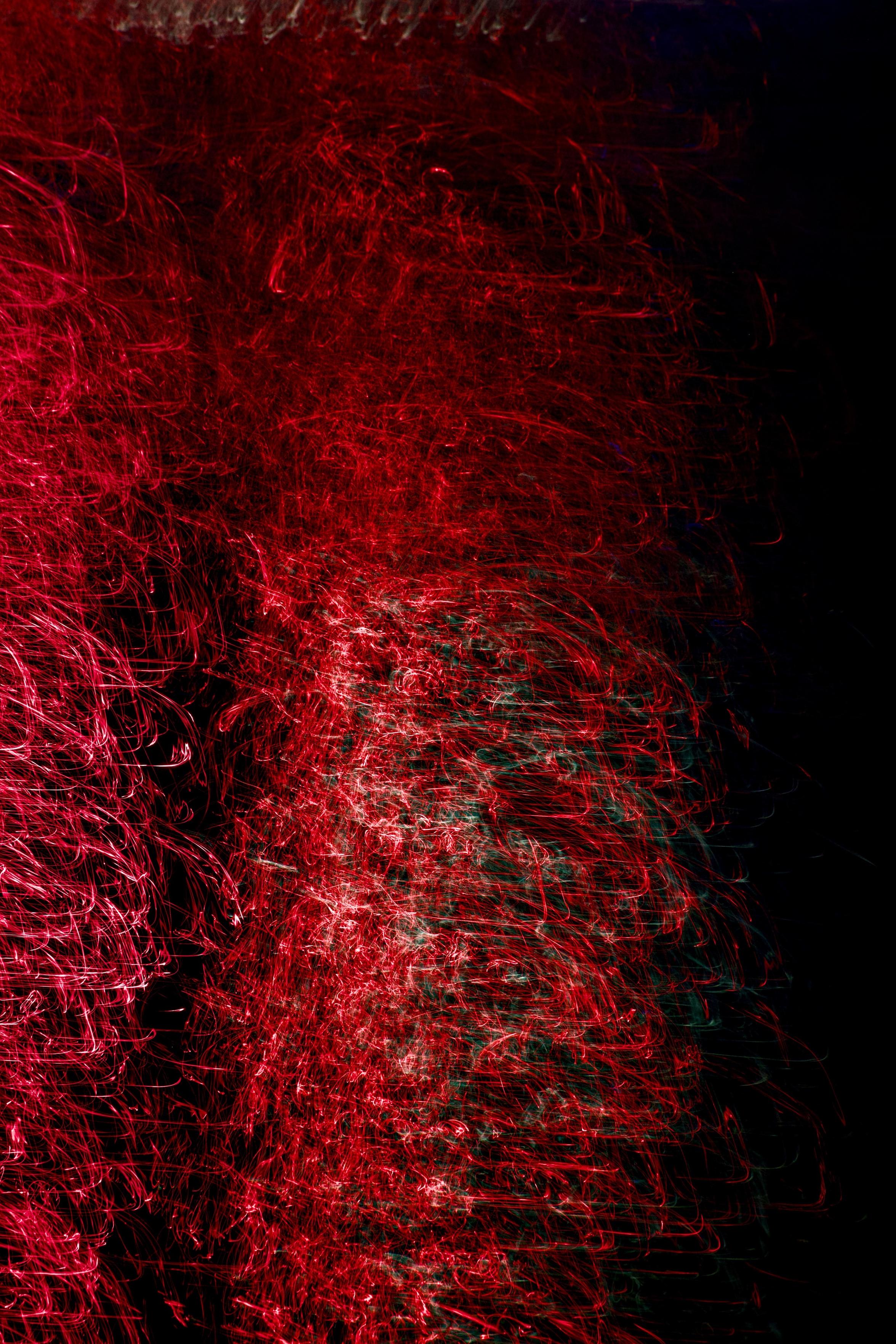 Intentional camera movement and a 1-second exposure creates a vivid, intense pattern of dancing red neon light on the surface of the River Clyde as it runs through Glasgow. Shot at night, the dark water is represented only by impenetrable shadows but there are the faintest hints of blue and green in the scene.