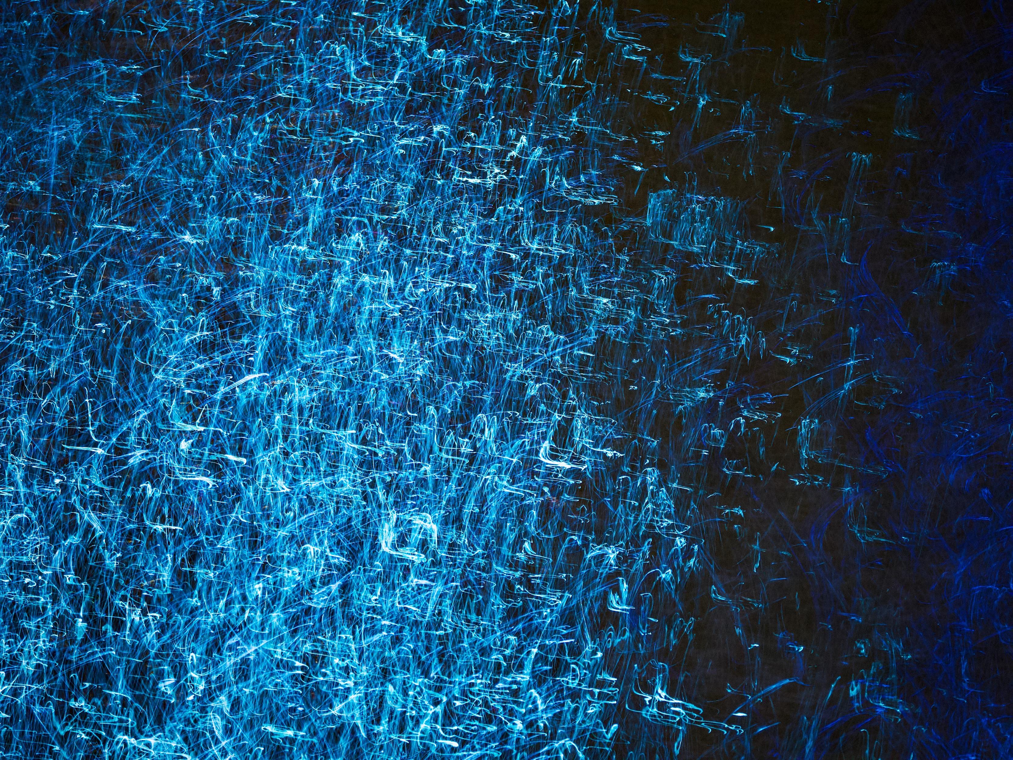 Intentional camera movement and a 1-second exposure creates swirling, scratchy lines of bright blue light on the surface of the River Clyde as it runs through Glasgow. Here the blue light dominates the scene but there are very faint hints of green, too.