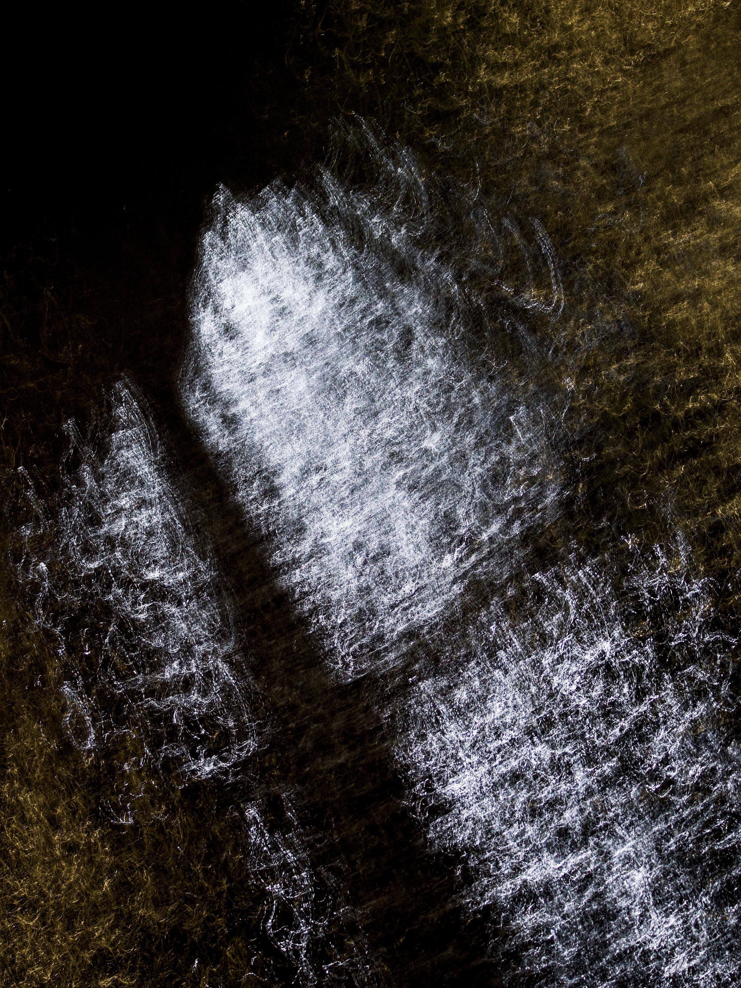Abstract image showing the reflections of golden yellow and bright white lights on the surface of the River Clyde at night, where a 1-second exposure and intentional camera movement has created abstract patterns.