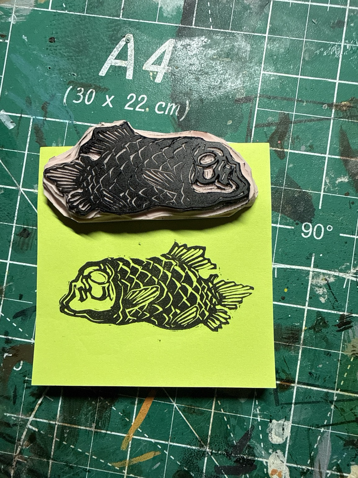 a rubber stamp of a stout black fish with heavy scales and a see-through head.  it has stalk eyes inside the clear head dome