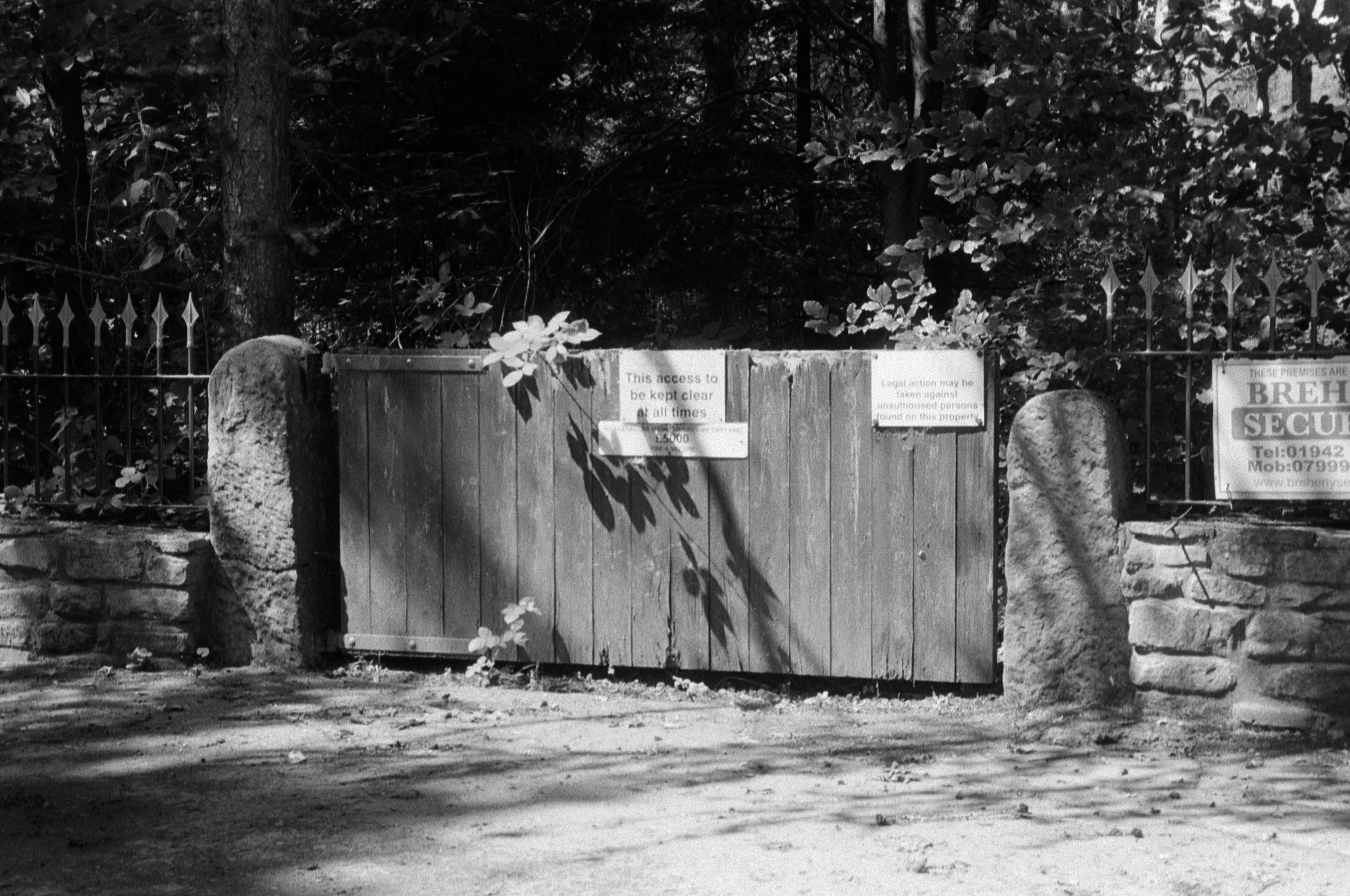 A black and white film photo of a gate at one of the local farms