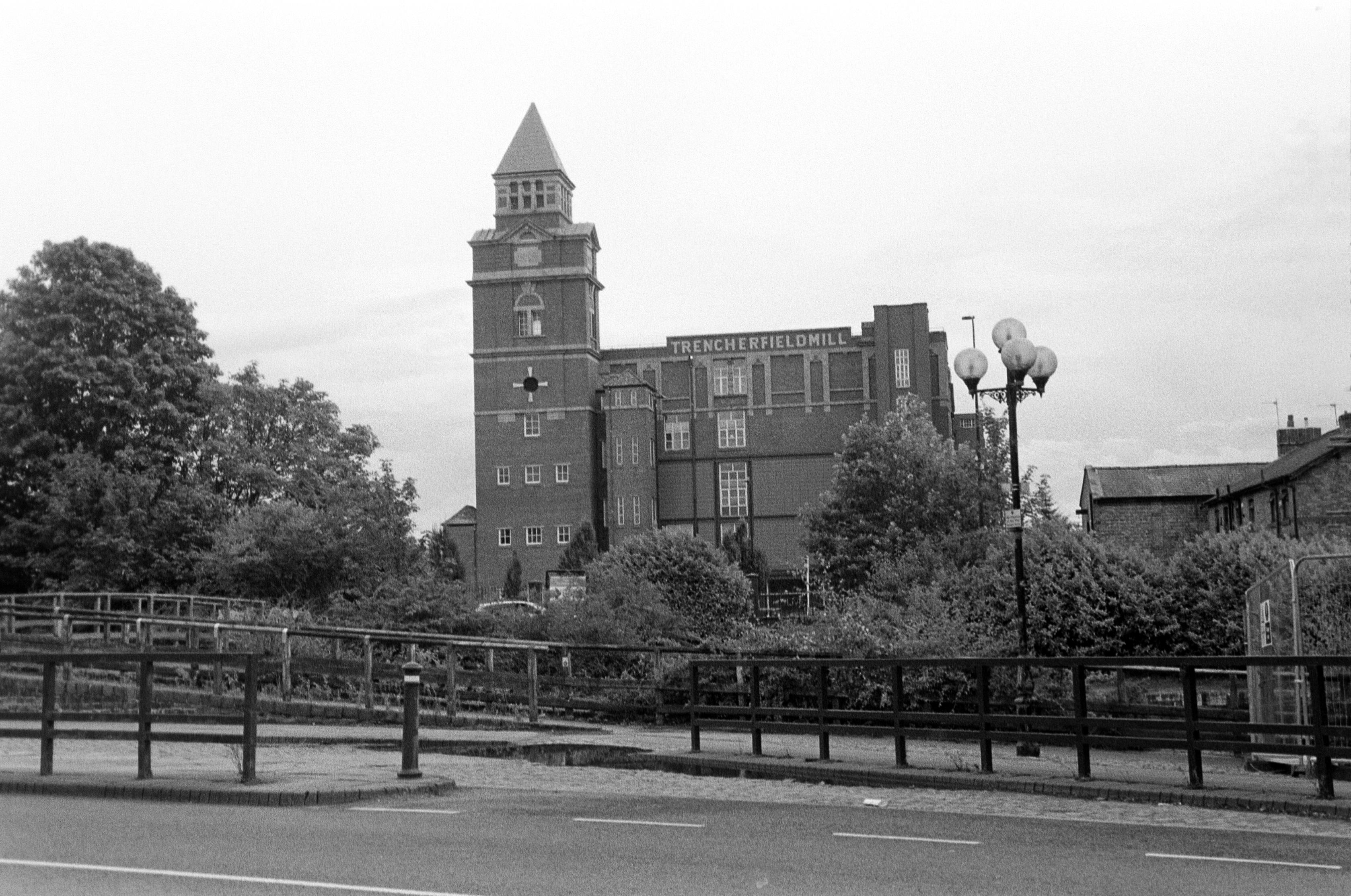A black and white film photograph of Trencherfield Mill in Wigan, looking from between Pier 1 and Pier 2 at the Wigan Pier quarter on Wallgate.
